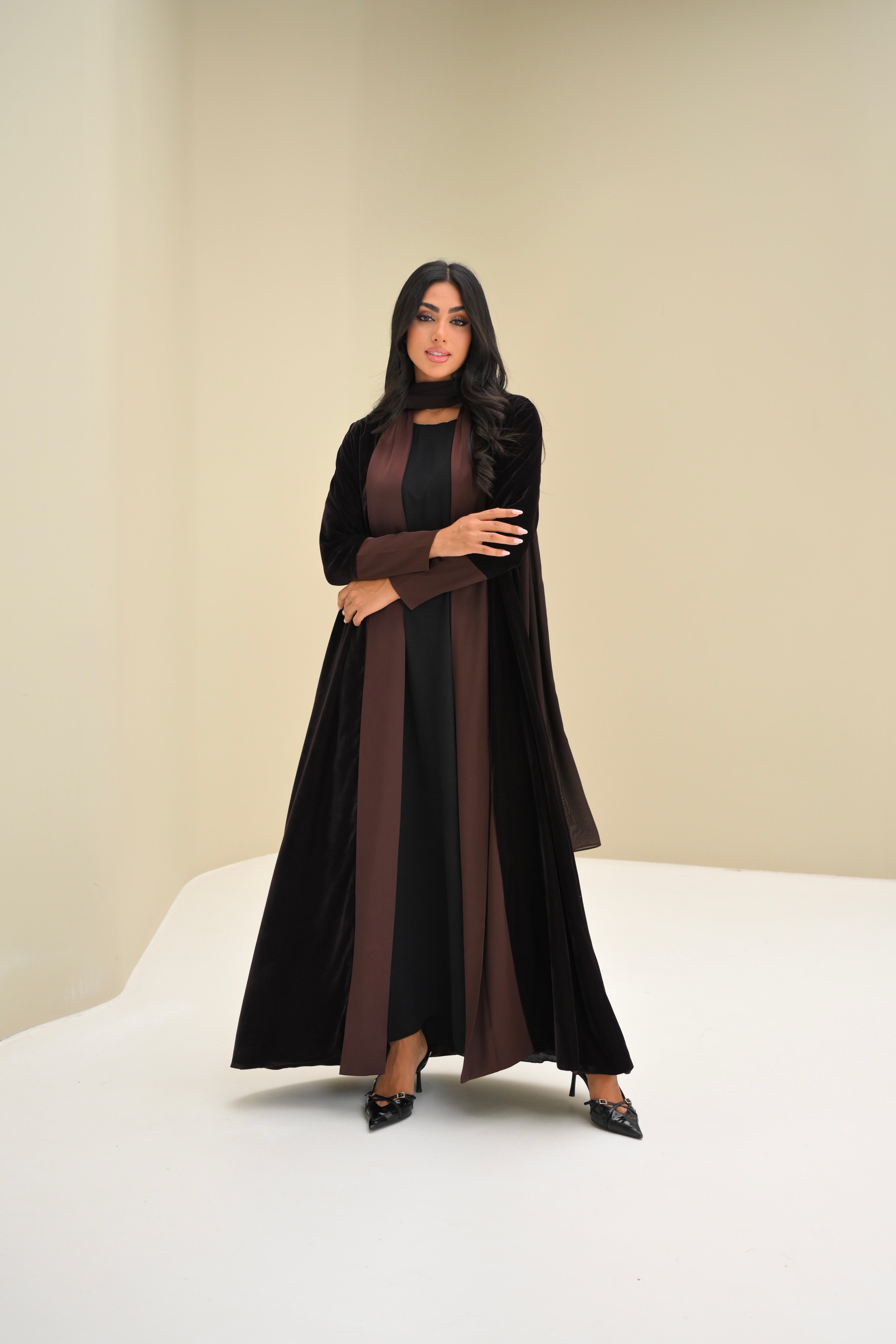 Woman wearing a black and brown abaya on a white background
