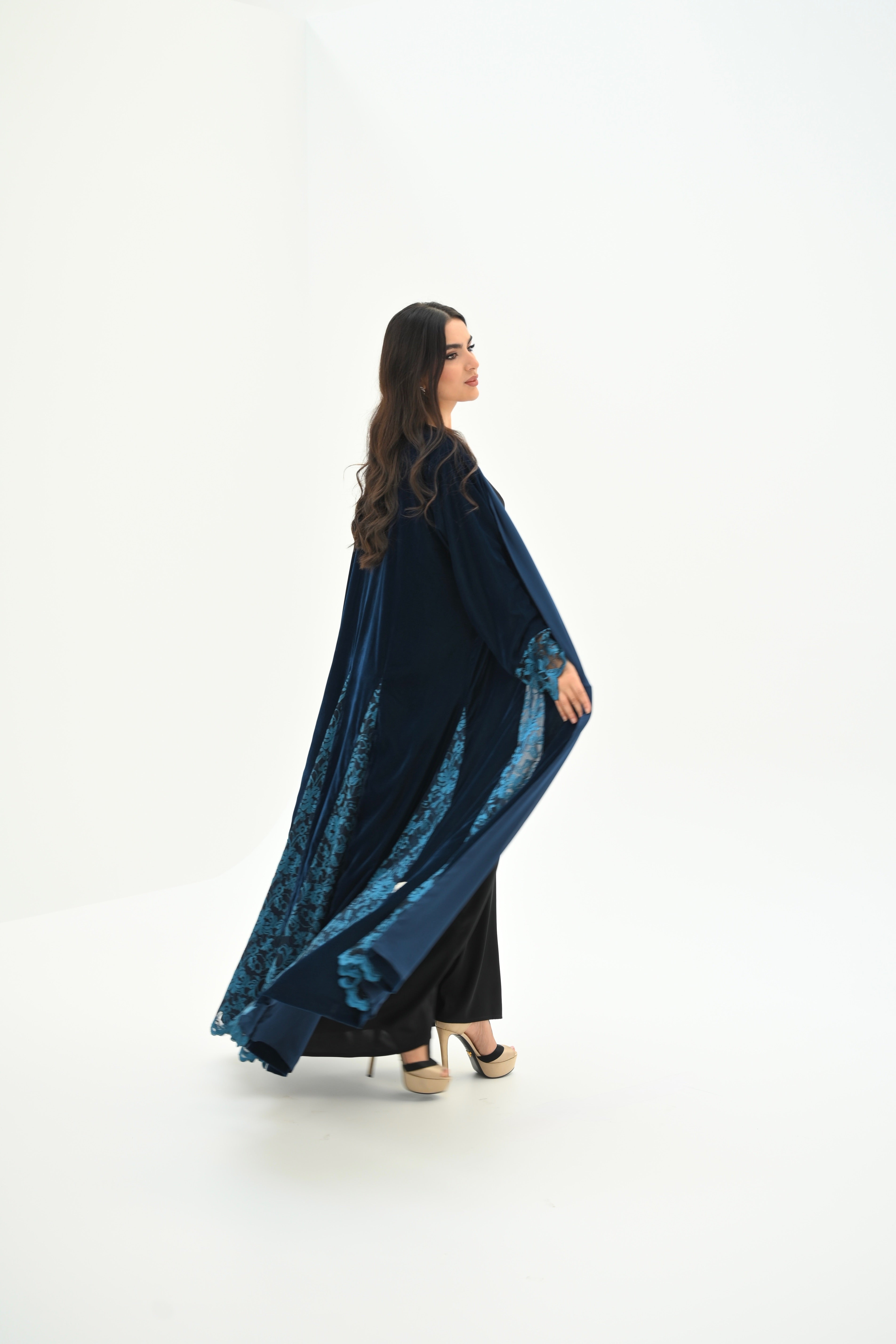 Woman wearing a blue and black patterned dress on a white background
