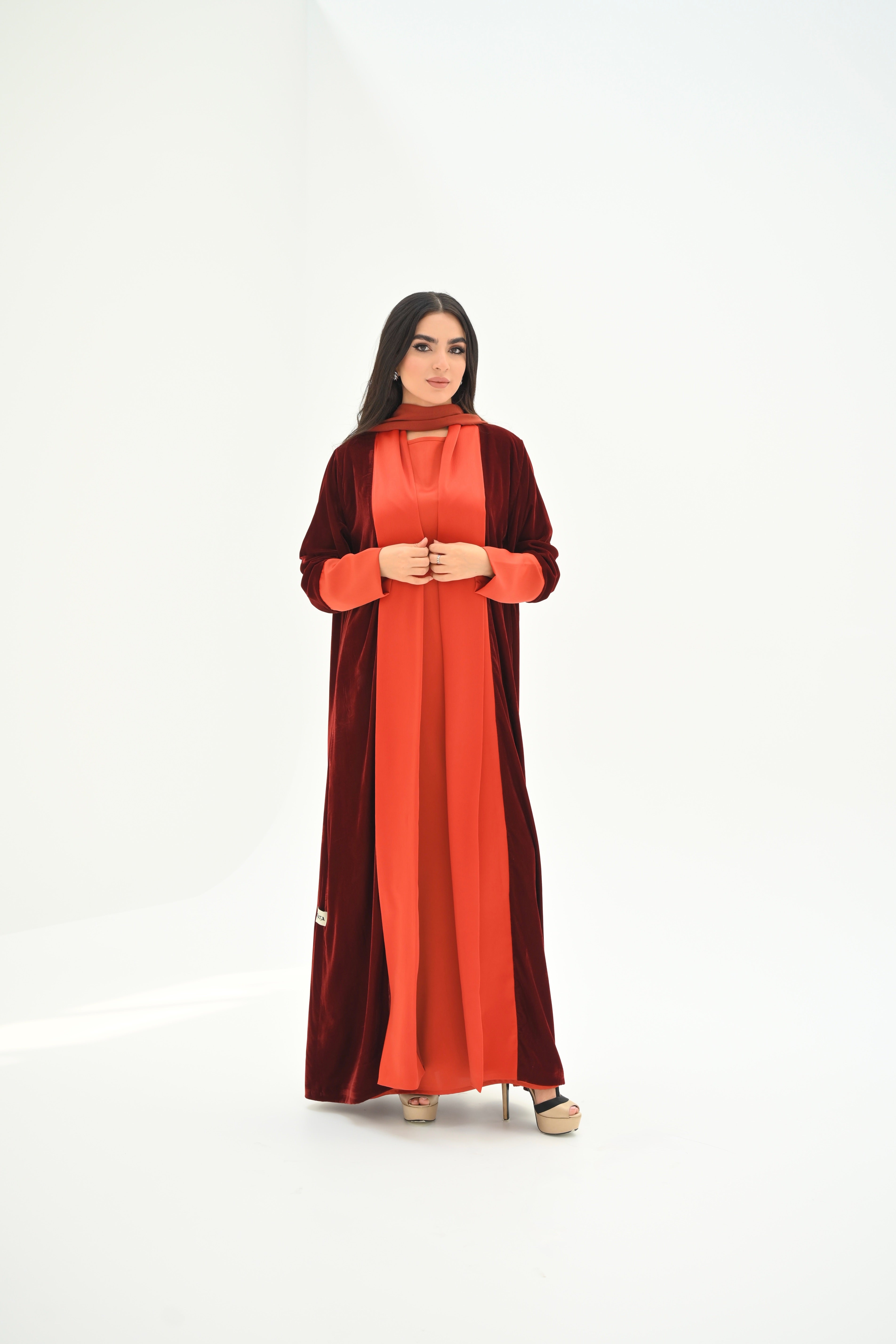 Woman wearing a red and brown dress on a white background