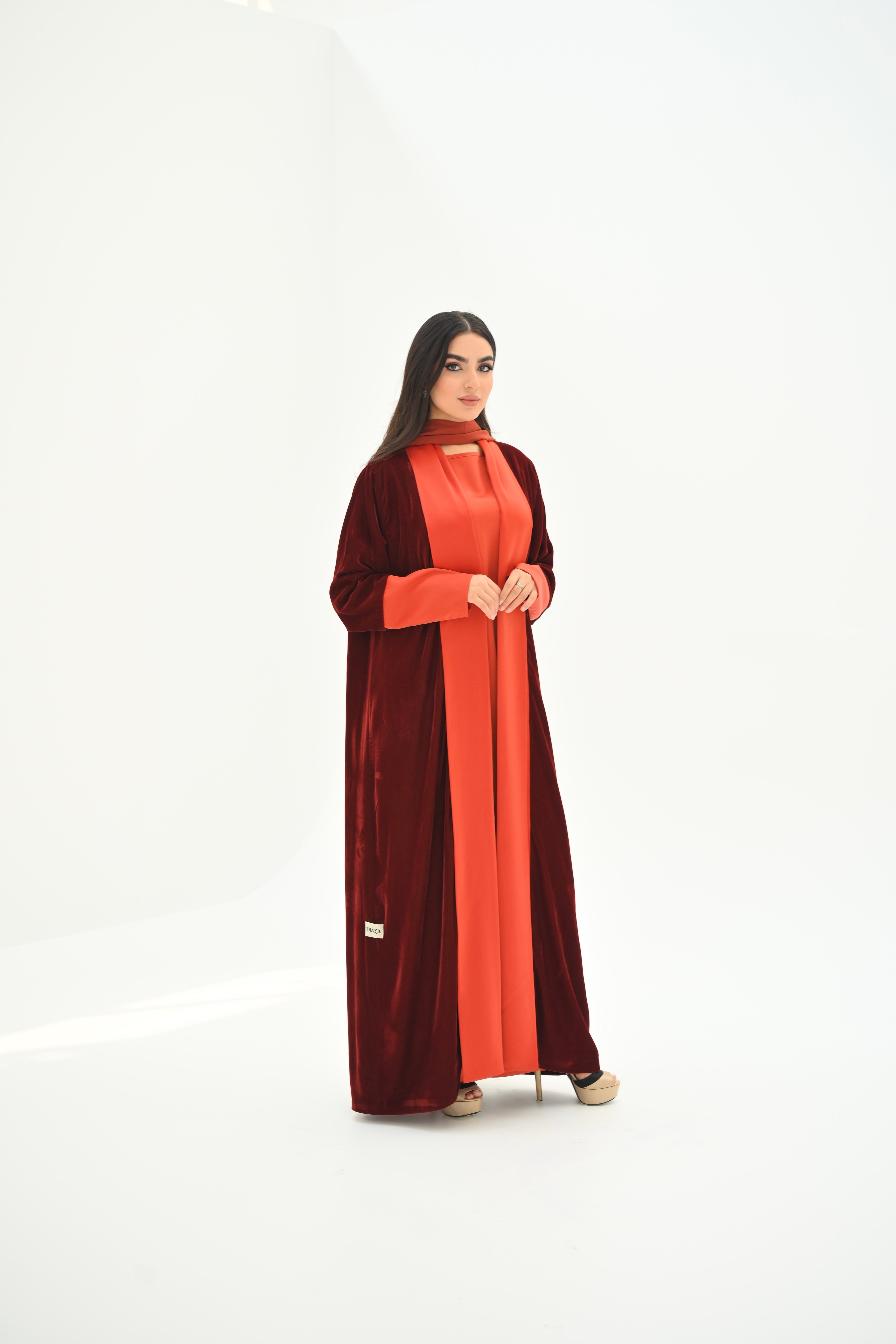 Woman wearing a two-tone red and brown dress on a white background