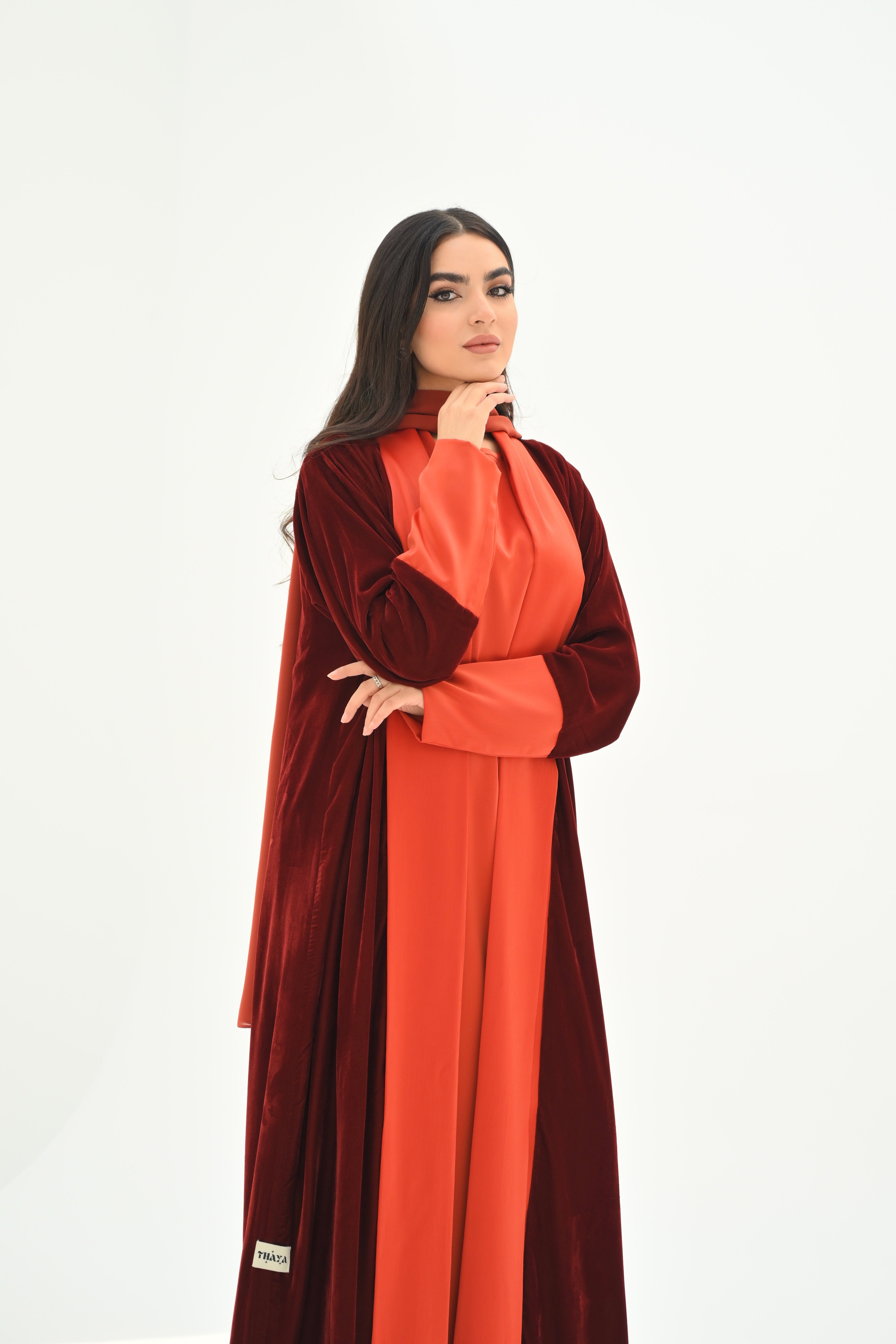 Woman wearing a red and brown dress on a white background