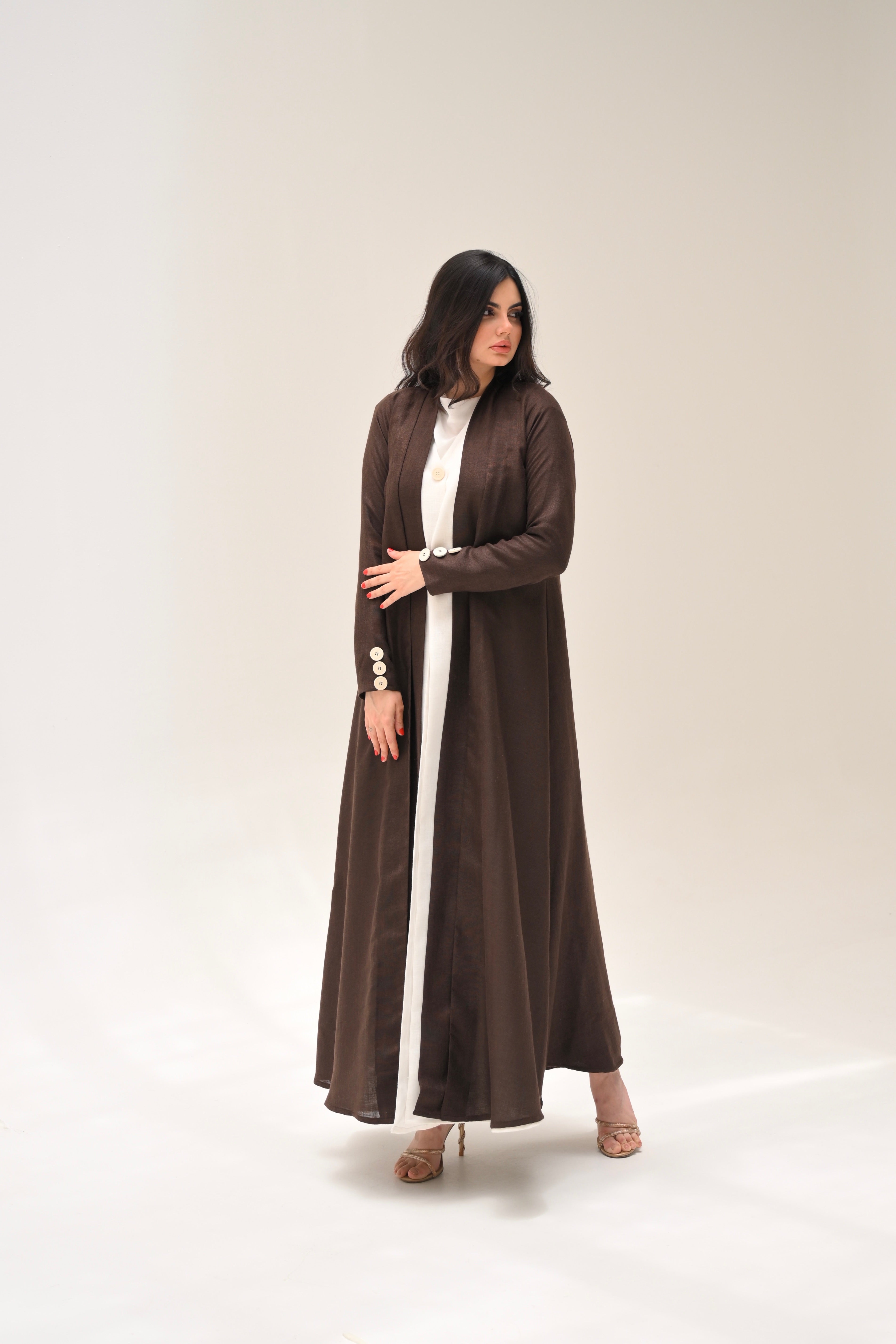 Woman wearing a long brown dress on a white background