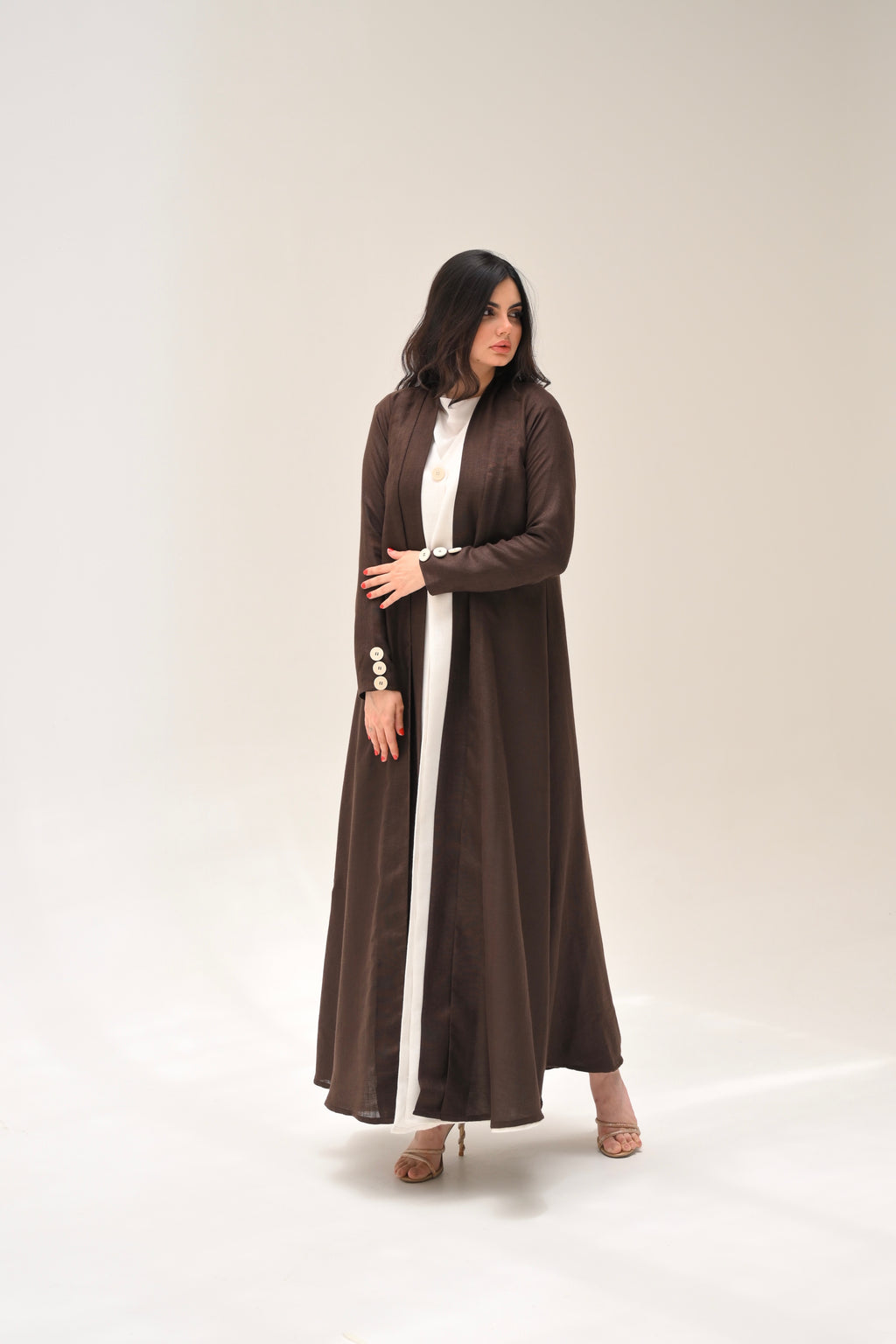Woman wearing a long brown dress on a white background