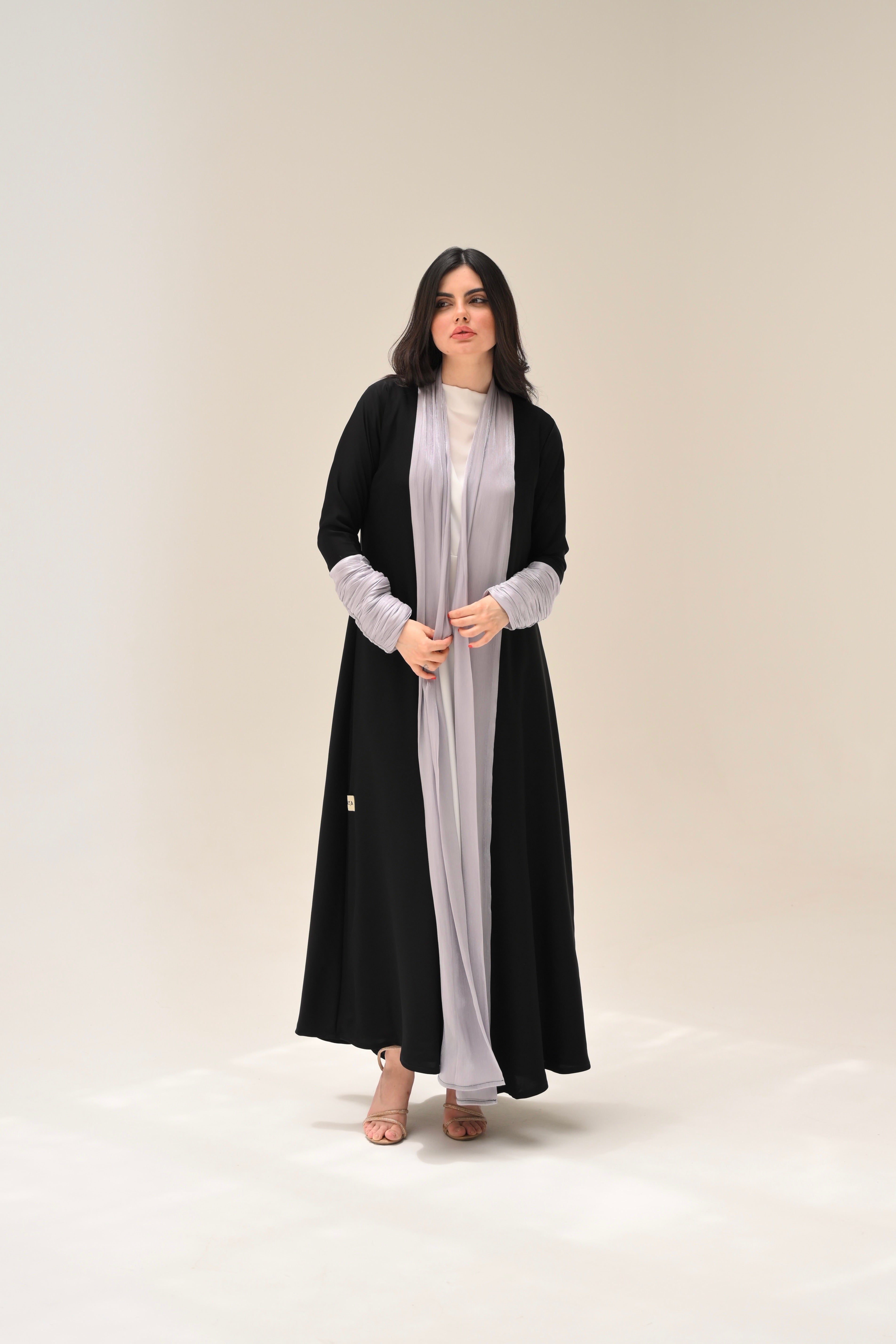 Woman wearing a black and white outfit on a beige background